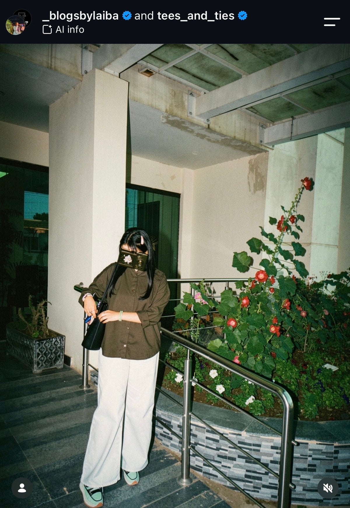 Customer in an olive shirt with white wide leg trousers on garden steps