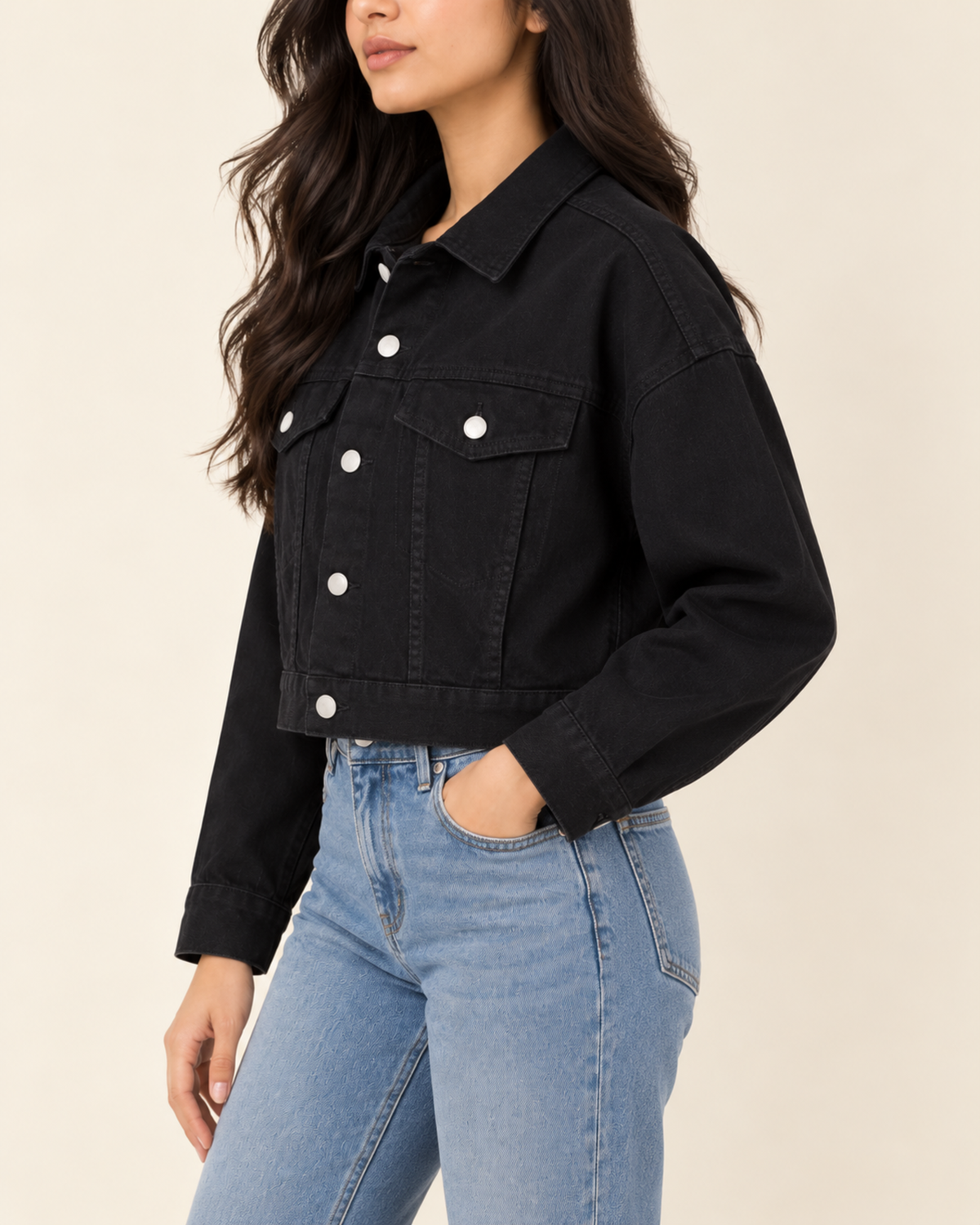Cropped black denim jacket with light blue jeans, side view