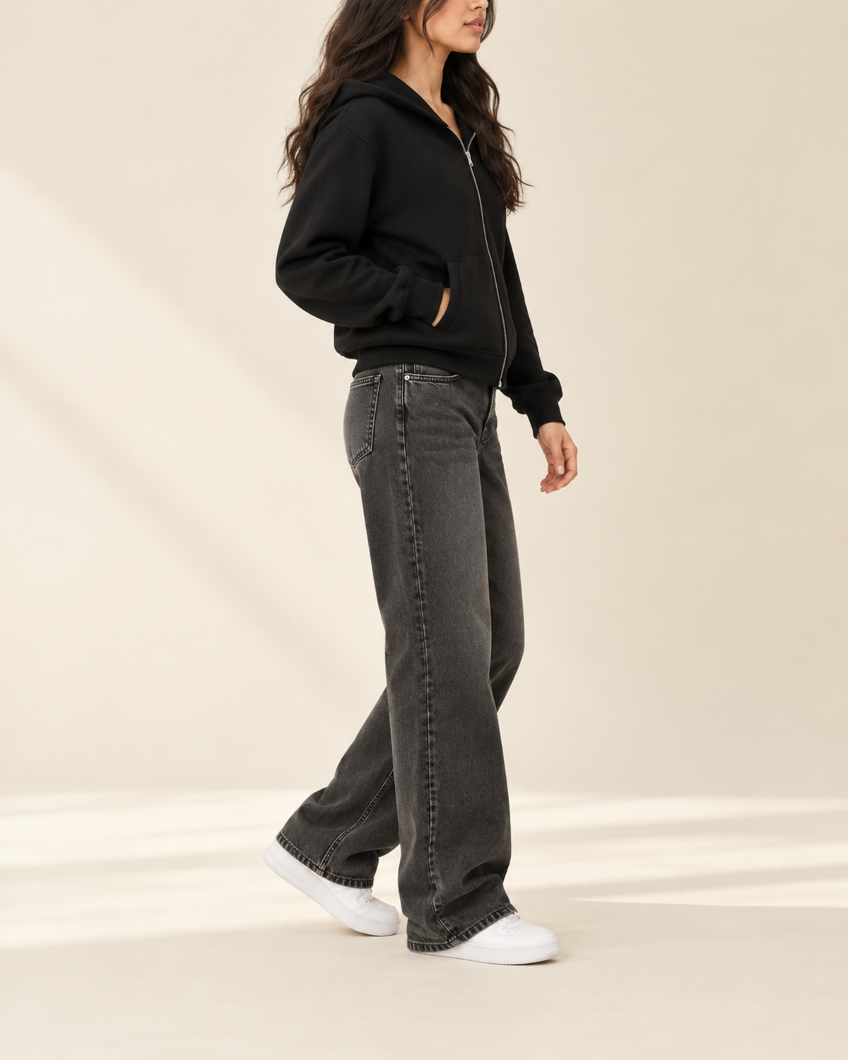 Black zip-up hoodie and charcoal wide-leg jeans, side view