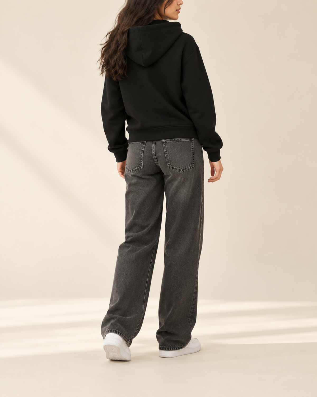 Back view of black zip-up hoodie with charcoal wide-leg jeans