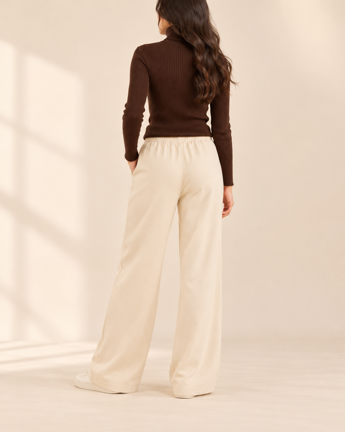 Back view of brown ribbed high-neck top with beige flapper trousers