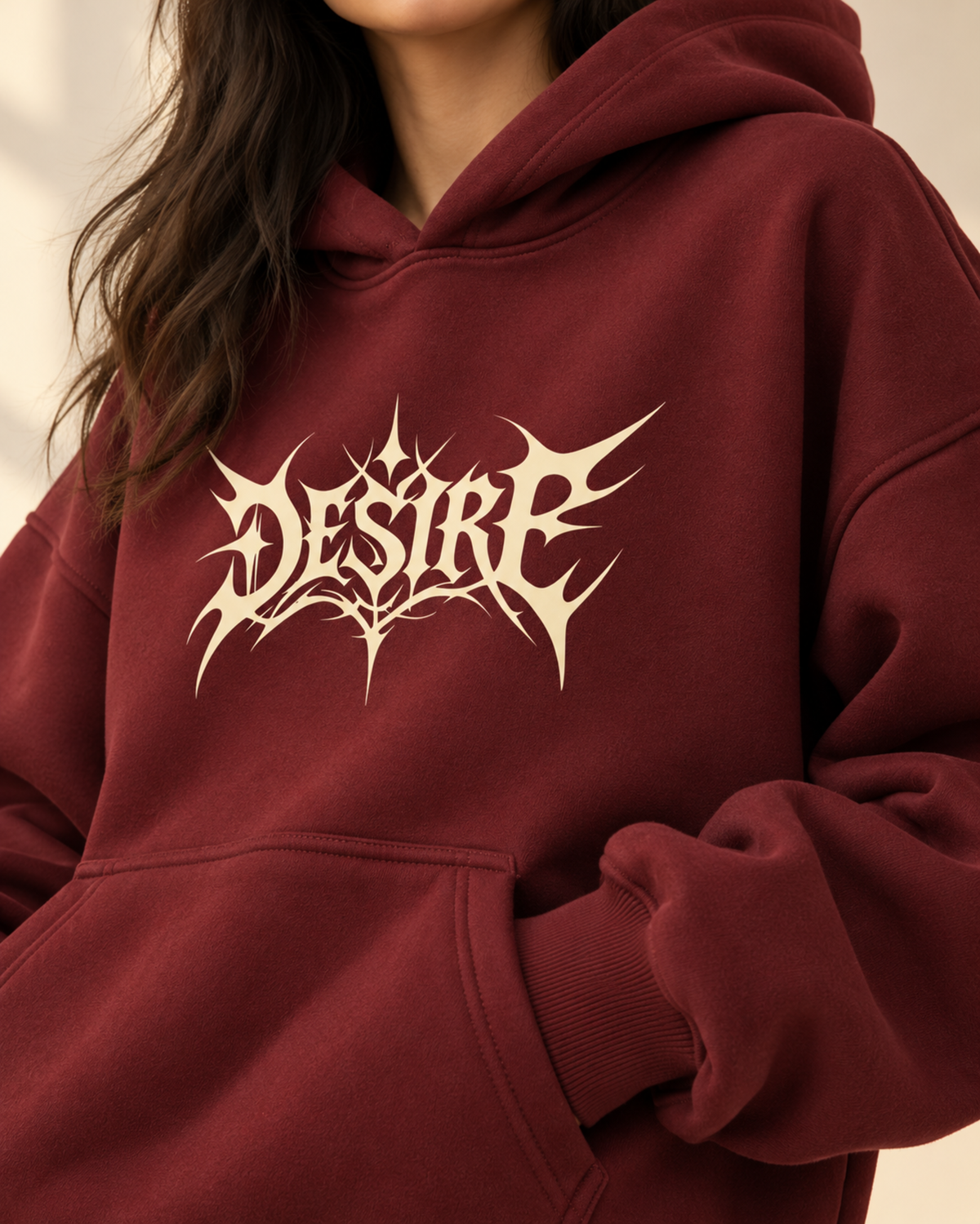 Close-up of cream Desire print on maroon hoodie