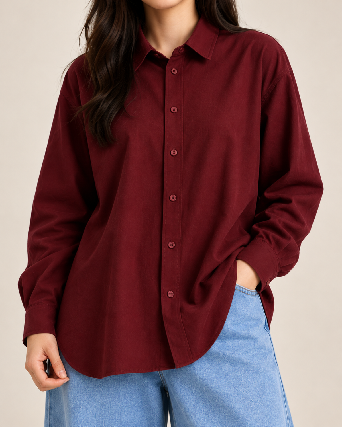 Close-up of maroon button-down shirt buttons and hem with sky blue jeans