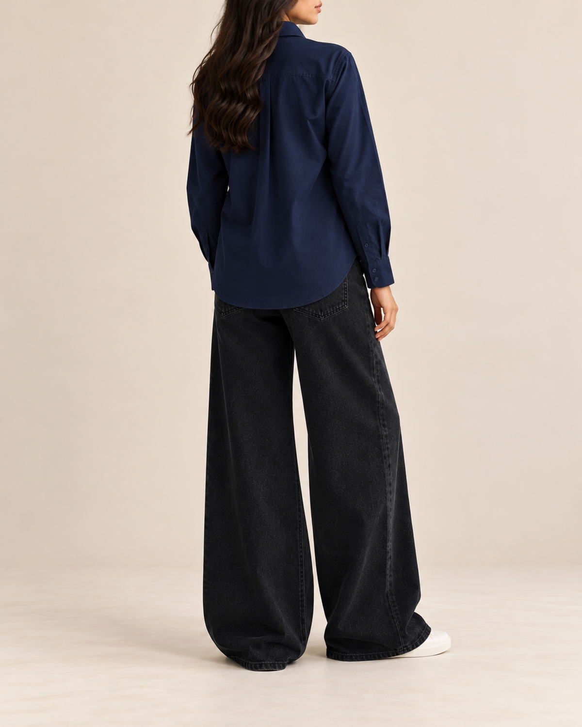 Navy button-down shirt and black wide-leg jeans, side view
