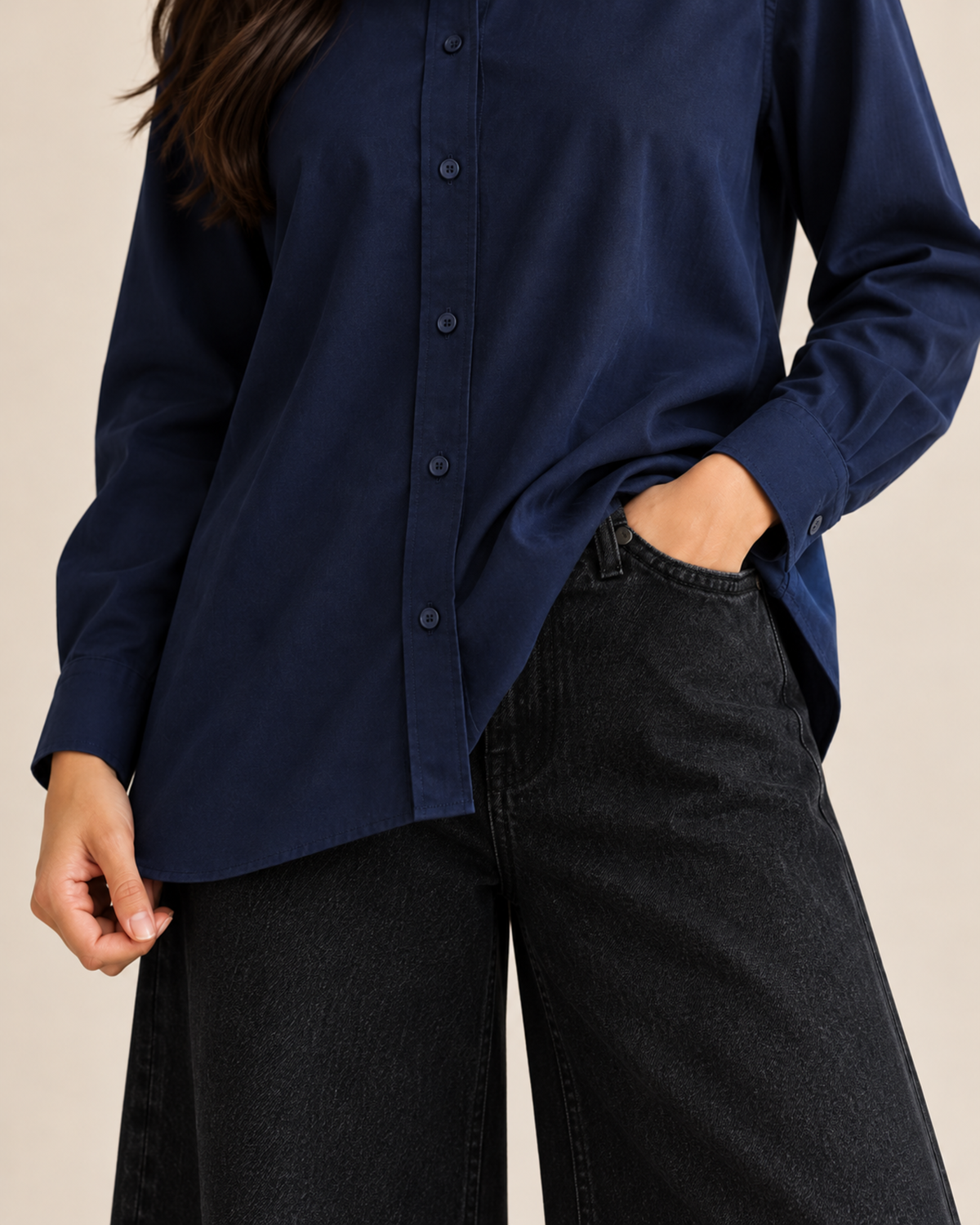 Close-up of navy button-down shirt buttons and hem with black jeans