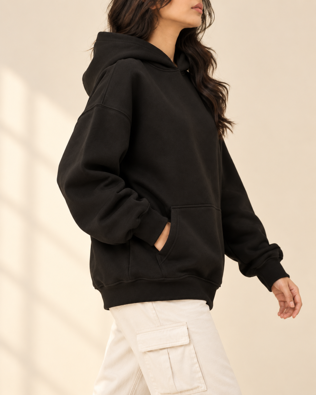 Black oversized hoodie with white cargo trousers, side view