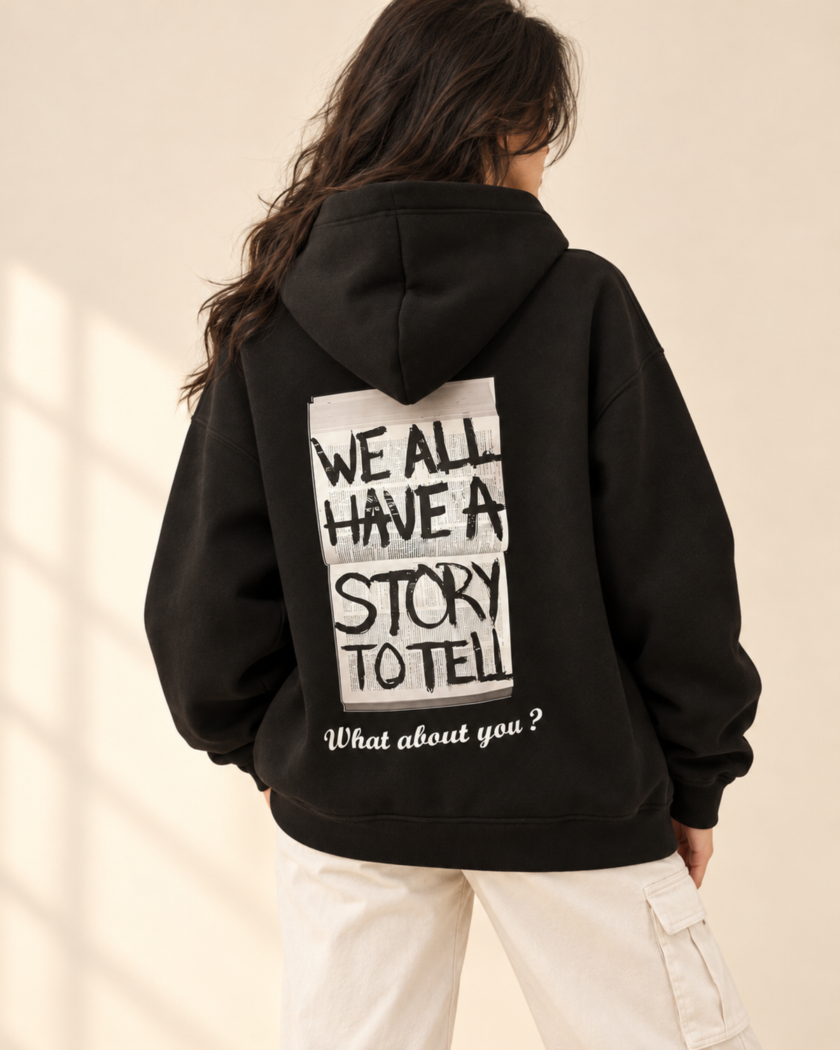 Back view of black hoodie with We All Have a Story to Tell print