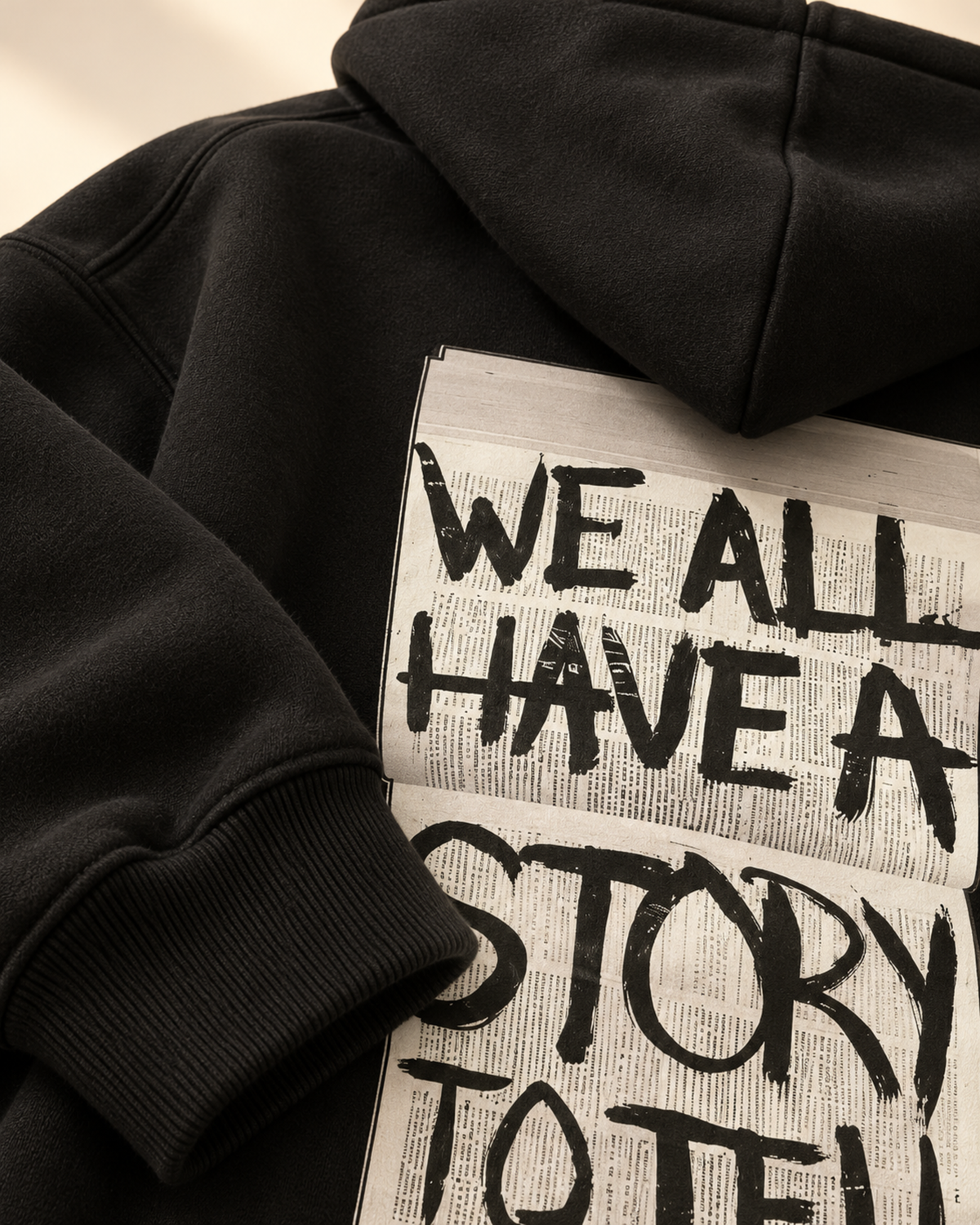 Close-up of We All Have a Story to Tell print on black hoodie